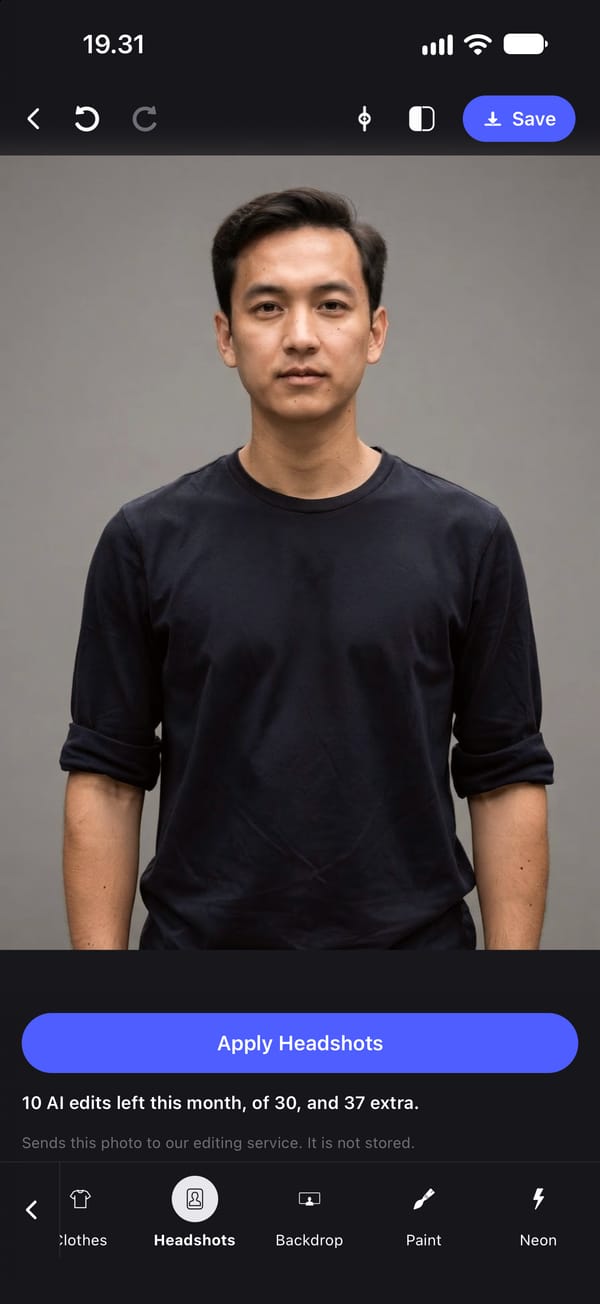 The same man after Apply Headshots: the park is replaced by a plain grey studio backdrop with even light, and his pose, expression, hair and T-shirt are the same.